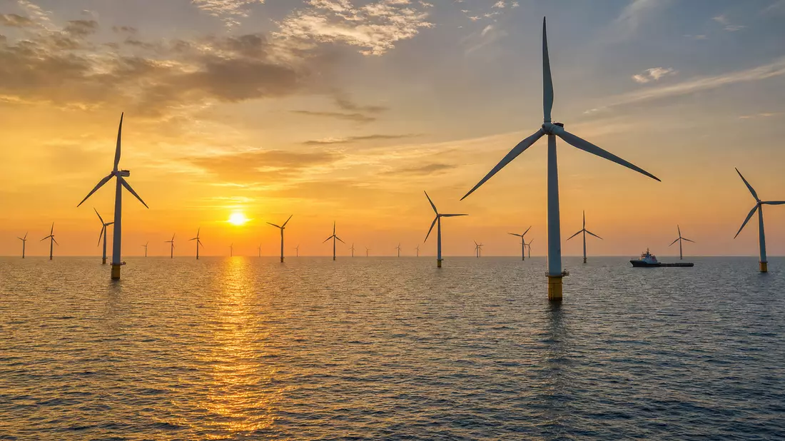 Offshore-Windpark mit Windturbinen im Meer bei Sonnenuntergang