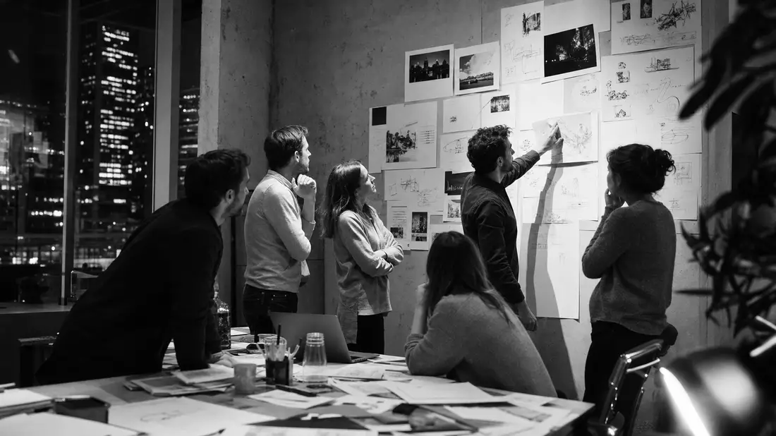 Schwarzweiß-Reportage: nächtliches Brainstorming eines Werbeagentur-Teams an Konzeptwand