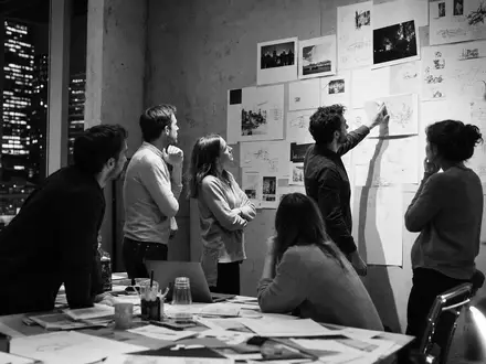 Schwarzweiß-Reportage der WPP plc (ISIN JE00B8KF9B49) dokumentiert ein nächtliches Brainstorming eines kreativen Werbeagentur-Teams intensiv - Foto: THN