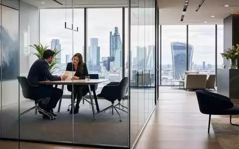 Aviva plc (ISIN GB0002162385) zeigt modernes Beratungsbüro in London mit Skyline-Blick und Kundengespräch - Foto: THN