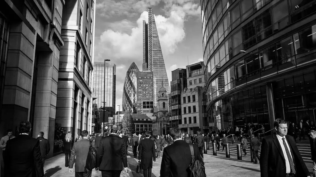 Schwarzweißfoto von Berufspendlern in Londons Finanzviertel mit Wolkenkratzern