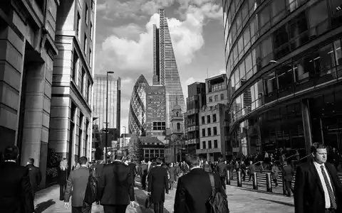 Aviva plc (ISIN GB0002162385) dokumentiert eine Schwarzweiß-Straßenszene im Finanzdistrikt Londons mit vielen Berufspendlern - Foto: THN