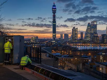 BT Group plc (ISIN GB0030913577) betreibt Telekom-Infrastruktur mit Technikern an Kabelverteilern in London bei Dämmerung - Foto: THN