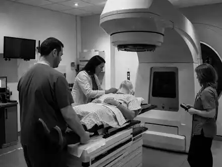 Dokumentarische Schwarzweiß-Reportage über Elekta AB SE0000163628 zeigt Klinikteam bei Vorbereitung einer Strahlentherapie-Behandlung - Foto: THN