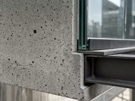 Allreal Holding AG (CH0008837566) zeigt eine Makroaufnahme von Beton- und Glasstruktur einer modernen Fassade - Foto: THN