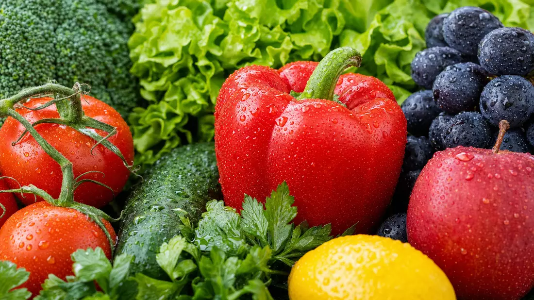 Makrofoto von frischem Gemüse und Obst mit Wassertropfen in Nahaufnahme