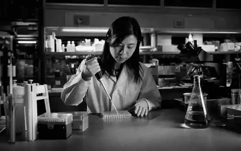 Illumina Inc. zeigt US4523271090 in dokumentarischer Schwarzweiß-Reportage einer Wissenschaftlerin beim Pipettieren im Labor - Foto: THN