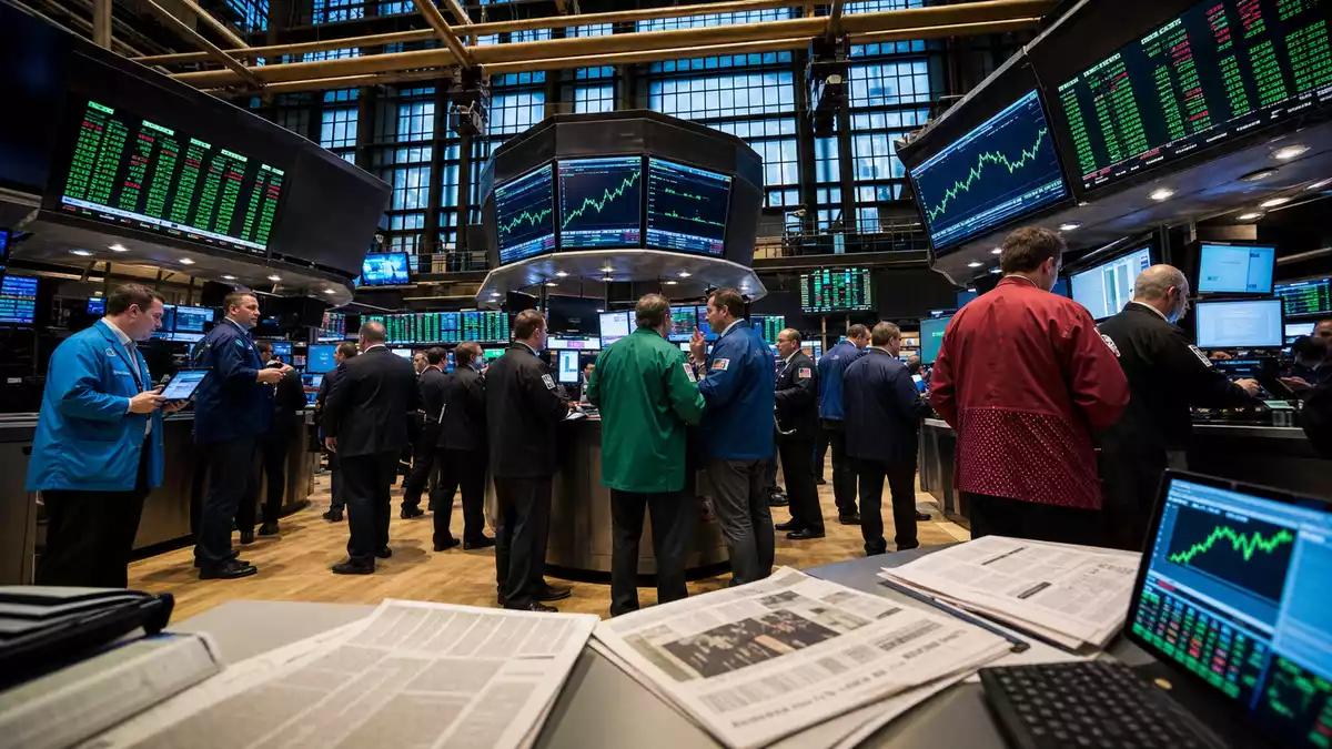 Börsenparkett NYSE mit Händlern in farbigen Jacken und industriellen Kursanzeigen auf Bildschirmen