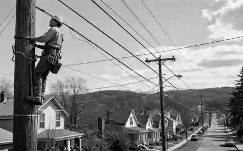 Charter Communications US16119P1084 dokumentarische Schwarzweiß-Reportage zeigt Techniker beim Klettern auf Versorgungsmast in amerikanischer Kleinstadt - Foto: THN