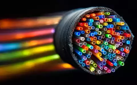 Charter Communications US16119P1084 extremes Makro Glasfaserkabel Querschnitt leuchtende bunte Lichtfasern auf schwarzem Hintergrund - Foto: THN
