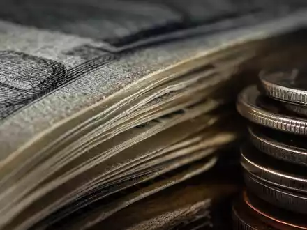 KeyCorp mit ISIN US4932671088 ist im Finanzsektor tätig, Makroaufnahme zeigt Banknoten und Münzen in Nahaufnahme - Foto: THN
