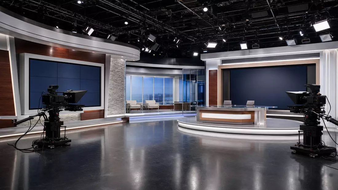 Modernes TV-Studio mit Kameras, Regiepult und beleuchteten Videowänden ohne Markenkennzeichen