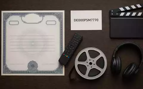 ProSiebenSat.1 Media DE000PSM7770 zeigt ein Flatlay mit Aktienzertifikat, ISIN-Karte, Fernbedienung und Filmutensilien auf Holztisch - Foto: THN