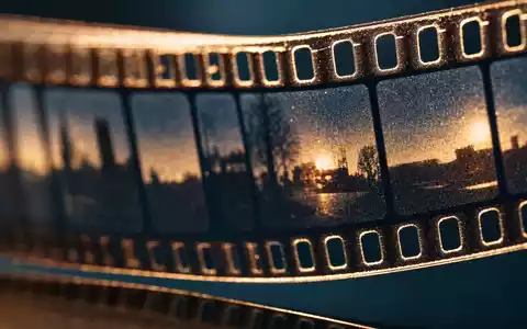 ProSiebenSat.1 Media DE000PSM7770 fokussiert eine Makroaufnahme von analogem Filmmaterial mit sichtbaren Perforationslöchern und Filmkorn - Foto: THN