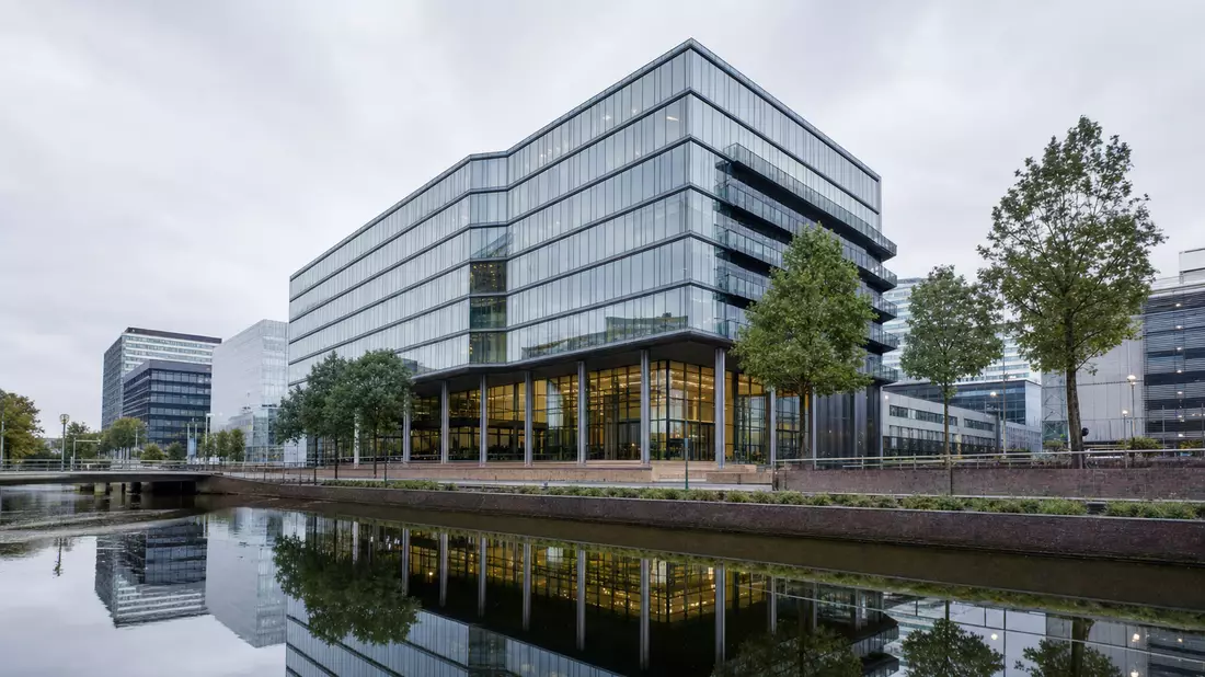 Modernes Glas-Bürogebäude in Amsterdam am Kanal, Sitz einer Beteiligungsholding
