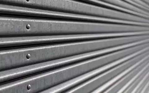 Makroaufnahme einer Metalltür-Textur zeigt Materialdetail passend zu Public Storage, Aktie ISIN US74460W1099, im REIT-Sektor - Foto: THN