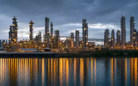 Wacker Chemie AG (DE000WCH8881) betreibt große Chemieanlagen mit Türmen und Rohrleitungen am Flussufer - Foto: THN