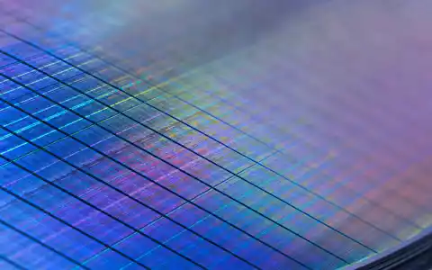 Wacker Chemie AG (DE000WCH8881) Makroaufnahme zeigt eine polierte Siliziumwafer-Oberfläche mit schillernden, farbigen Lichtreflexionen - Foto: THN