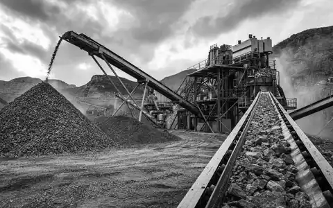 Vulcan Materials US9291601097 dokumentiert schwarzweiße Reportage einer Steinbrecheranlage mit Förderbändern und riesigen Schotterhaufen im Industriegelände - Foto: THN