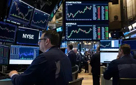Vulcan Materials US9291601097 zeigt NYSE Handelssaal mit Händlern vor Bildschirmen und Baustoffsektor-Charts im Hintergrund - Foto: THN