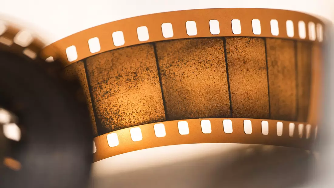Makroaufnahme eines beleuchteten 35mm-Filmstreifens mit sichtbaren Perforationen