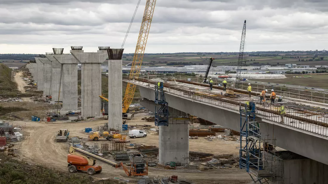 Fotorealistische Baustelle einer Autobahnbrücke mit Kränen und Bauarbeitern in Frankreich