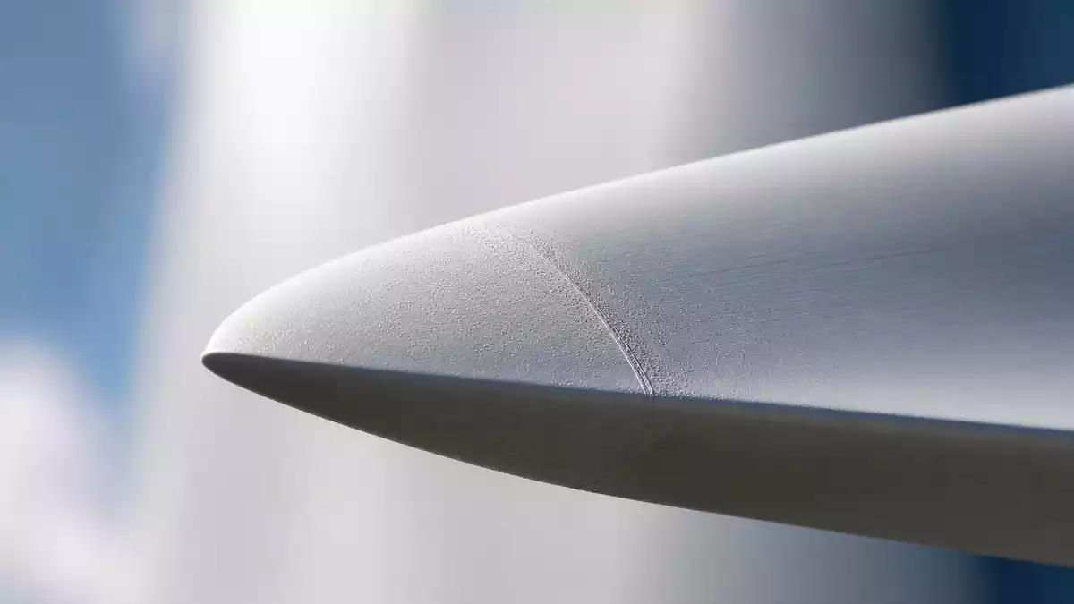 Makroaufnahme der glatten weißen Vorderkante eines Windturbinen-Rotorblatts