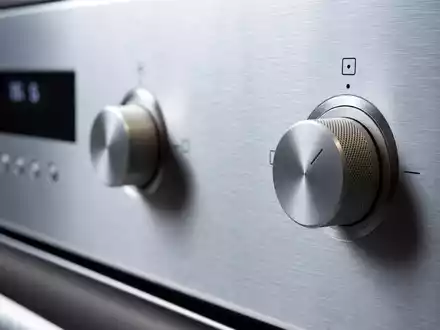 Electrolux AB (ISIN SE0016589188) zeigt eine Makroaufnahme von gebürstetem Edelstahl und präzisen Steuerknöpfen eines Haushaltsgeräts - Foto: THN