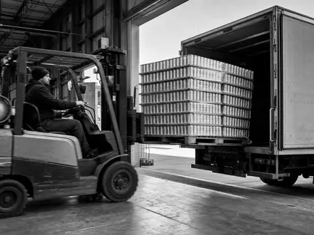 Dokumentarische Schwarzweißaufnahme eines Lagerarbeiters illustriert die Logistik von Monster Beverage, ISIN US61174X1090, im Getränke-Vertrieb weltweit - Foto: THN