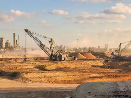 Mosaic Company US61945C1036 zeigt eine fotorealistische Phosphat-Tagebaumine mit großen Förderanlagen im warmen Abendlicht Floridas - Foto: THN