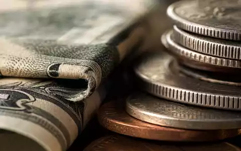Makroaufnahme von Banknoten und Münzen visualisiert die Branche der Morgan Stanley Aktie ISIN US6174464486 - Foto: THN