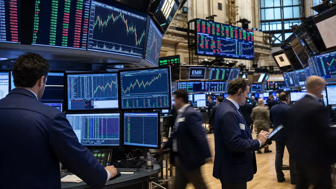 Börsenredaktionsfoto des NYSE-Handelsraums mit EMR-Ticker und Industriesektor-Charts auf Monitoren