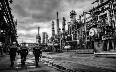 Neste Oyj FI0009013296 dokumentiert eine Schwarzweiß-Reportage von Arbeitern in einer großen petrochemischen Industrieanlage - Foto: THN
