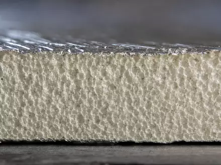 Makroaufnahme der Dämmmaterial-Textur veranschaulicht Kingspan Group plc, ISIN IE0004927939, mit Detailblick auf Zellstruktur und Folienbeschichtung - Foto: THN