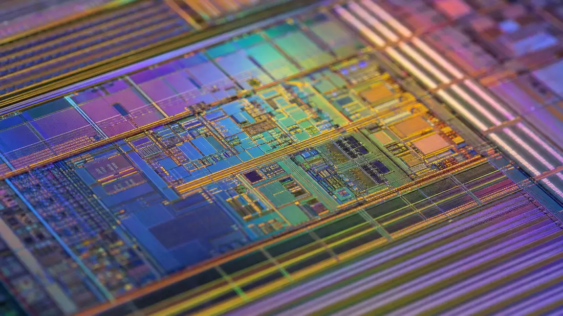 Extreme Nahaufnahme einer schillernden Mikrochip-Oberfläche mit feinen Schaltkreisstrukturen