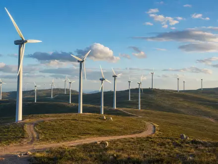 EDP Renováveis S.A. (ES0127797019) betreibt Onshore-Windparks mit vielen Turbinen auf hügeliger Landschaft im Abendlicht - Foto: THN