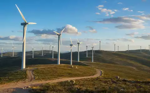 EDP Renováveis S.A. (ES0127797019) betreibt Onshore-Windparks mit vielen Turbinen auf hügeliger Landschaft im Abendlicht - Foto: THN