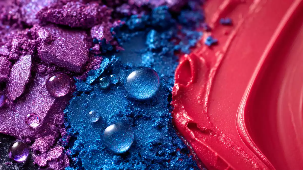 Extreme Nahaufnahme von schimmerndem Lidschattenpuder und Lippenstifttextur