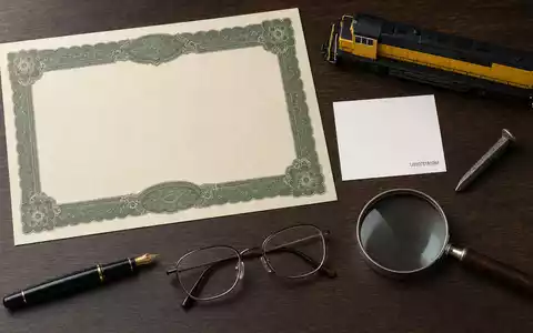 Flatlay mit Aktienzertifikat und ISIN-Karte symbolisiert Union Pacific Corp, Wertpapierkennung US9078181084, mit Lokomotiven-Modell und Werkzeugen - Foto: THN