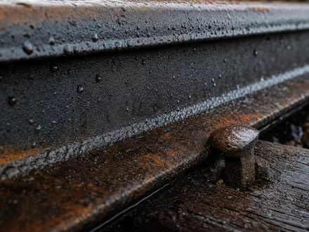 Makroaufnahme einer Bahnschiene mit Rostspuren veranschaulicht Union Pacific Corp, ISIN US9078181084, Materialdetail der Eisenbahninfrastruktur - Foto: THN