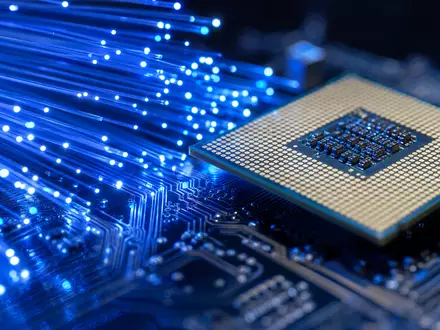 Oracle Corporation US68389X1054 visualisiert durch dramatische Makrofotografie leuchtender Glasfaserkabel neben einem detaillierten Computer-Prozessorchip mit Leiterbahnen - Foto: THN