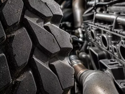 PACCAR Inc. US6937181088 gezeigt in extremer Makroaufnahme von Reifenprofil und Motorblock mit metallischen Details - Foto: THN