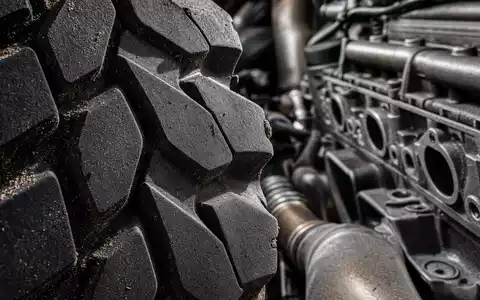 PACCAR Inc. US6937181088 gezeigt in extremer Makroaufnahme von Reifenprofil und Motorblock mit metallischen Details - Foto: THN