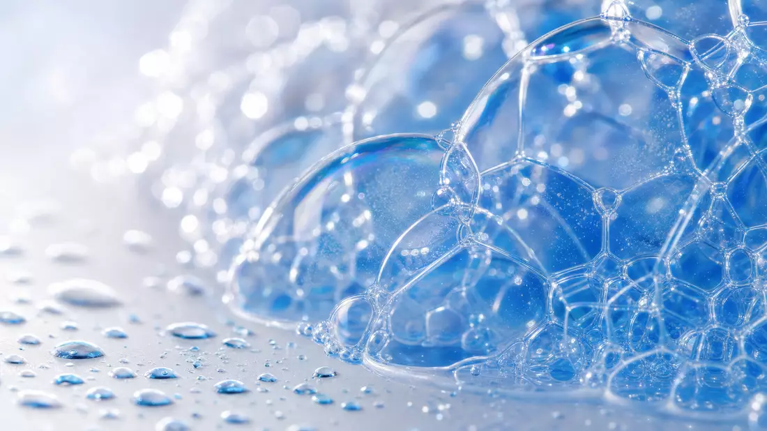 Extreme Makro-Aufnahme von Seifenschaumblasen und Wassertropfen in Blautönen