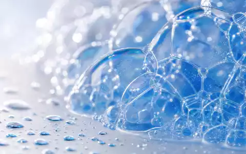 Clorox Co. Reinigungsmittel-Makro US1890541097 zeigt irisierenden Seifenschaum mit Wassertropfen in extremer Nahaufnahme - Foto: THN