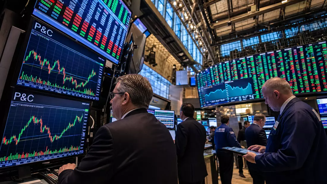 Editorialbild des NASDAQ-Handelssaals mit P&C-Charts und Händlern an Monitoren