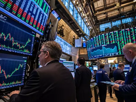 Cincinnati Financial US1720621011 NASDAQ-Handelssaal mit P&C-Aktiencharts Händler in Anzügen vor mehreren Monitoren - Foto: THN