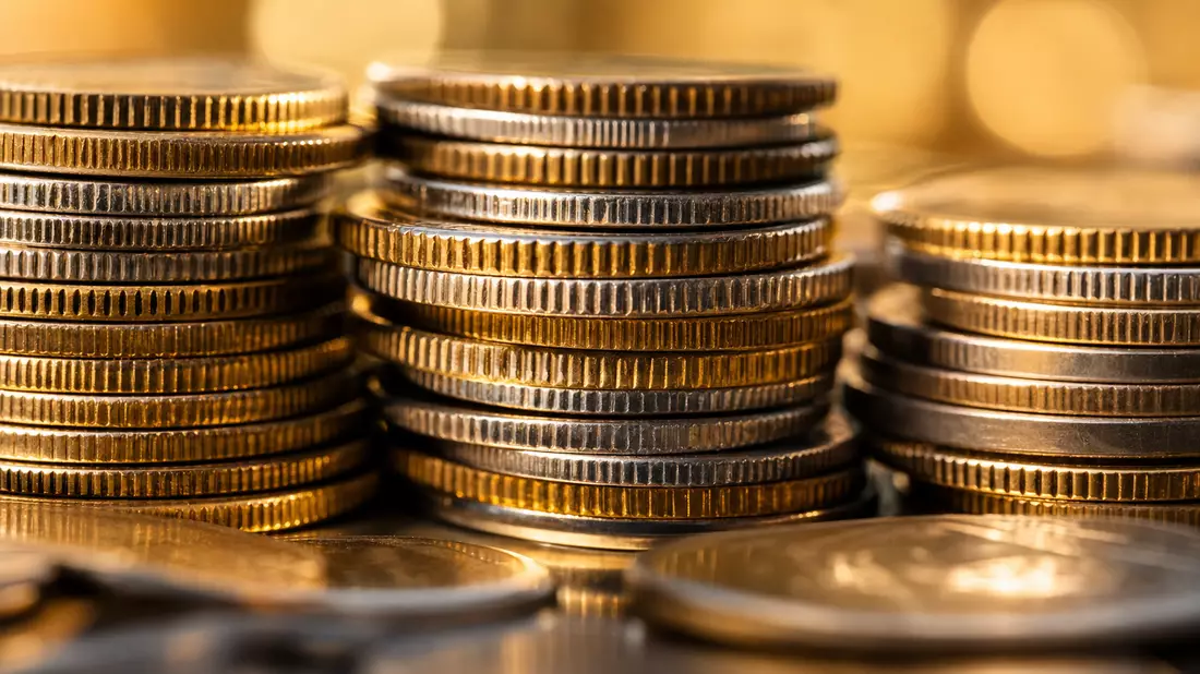 Extreme Makro-Nahaufnahme gestapelter Gold- und Silbermünzen mit gerändelten Kanten