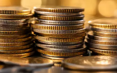 Citizens Financial Group Münz-Makro US1746101054: gestapelte Gold-Silbermünzen mit gerändelten Kanten im Vordergrund - Foto: THN