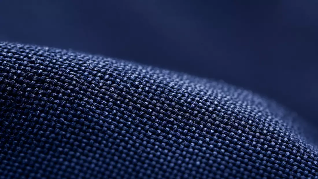 Extreme Nahaufnahme der Gewebestruktur eines marineblauen Arbeitsuniforms mit scharfem Fadenmuster